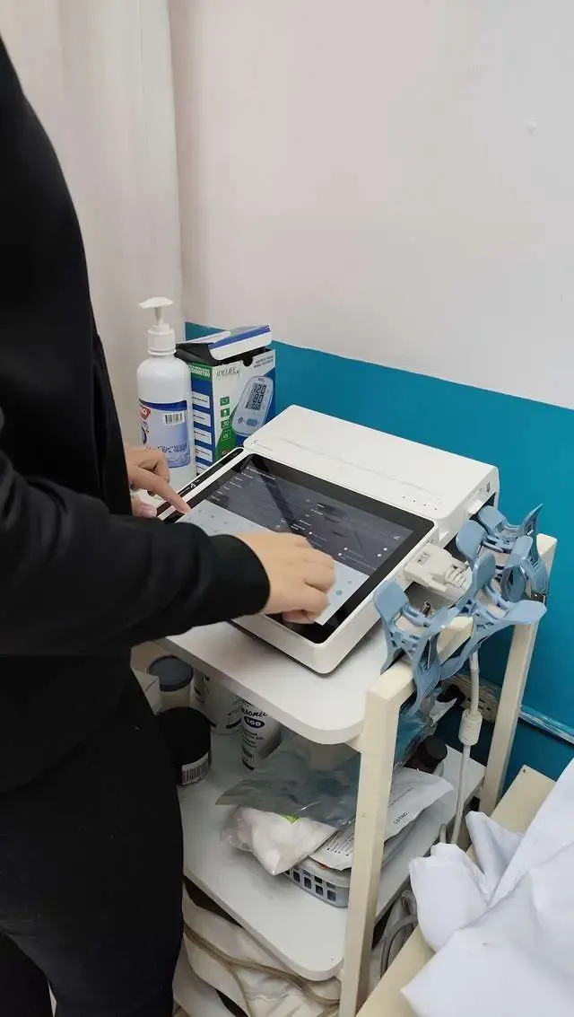 Especialista de CECP registrando datos en el electrocardiógrafo con pantalla táctil e inteligencia artificial