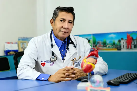 Dr. Vicente Sánchez Crespo, cardiólogo de CECP en Guayaquil, junto a un modelo anatómico del corazón en su consultorio